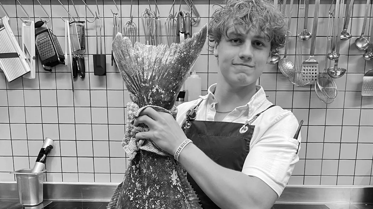 Emil holding a whole turbot in the kitchen